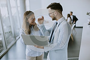 Young business couple working and discussing by laptop in the office