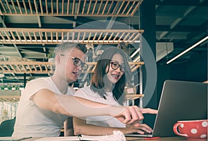 Young business couple working with laptop together