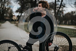 Young business entrepreneur fixing bicycle in a park setting