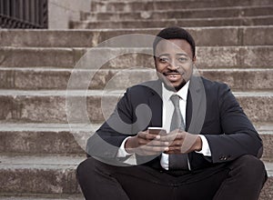 Young business entrepreneur man sitting outdoors urban stairs working and using smart phone