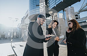 Young business entrepreneurs working together outdoors in an urban setting.