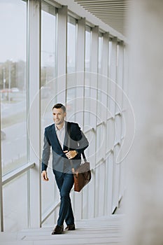 Young business executive with briefcase going up the stairs