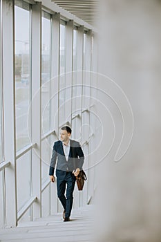 Young business executive with briefcase going up the stairs