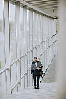 Young business executive with briefcase going up the stairs