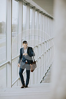 Young business executive with briefcase going up the stairs