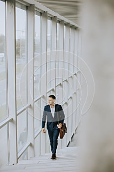 Young business executive with briefcase going up the stairs