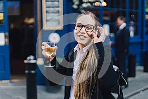 Young business lady in glasses standing by the pub.