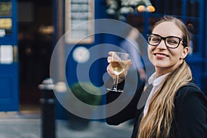 Young business lady in glasses standing by the pub.