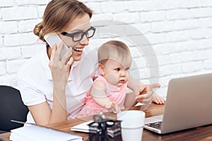 Young business lady try to work with cute baby.