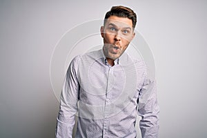 Young business man with blue eyes standing over isolated background afraid and shocked with surprise expression, fear and excited
