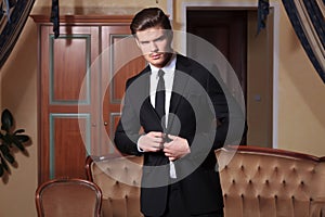 Young business man buttoning his suit