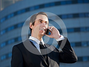 Young business man calling by mobile phone outdoors