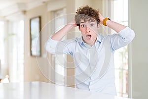 Young business man with curly read head Crazy and scared with hands on head, afraid and surprised of shock with open mouth