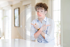 Young business man with curly read head Pointing to both sides with fingers, different direction disagree