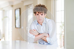 Young business man with curly read head shaking and freezing for winter cold with sad and shock expression on face