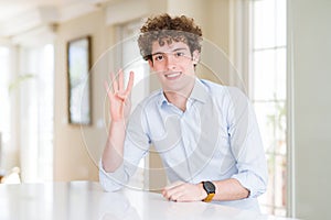 Young business man with curly read head showing and pointing up with fingers number four while smiling confident and happy