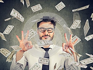 Business man meditating under money rain photo