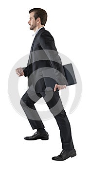 Young business man go walk making step  businessman wear elegant black suit and and holding a laptop or folder. isolated over