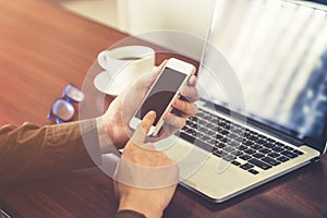 Young business man hand holding and using phone in the office wi