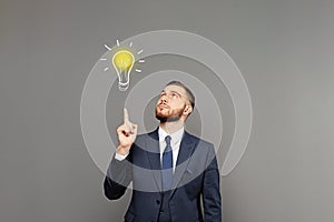 Young business man have an idea light buld on gray wall banner background. Business idea concept