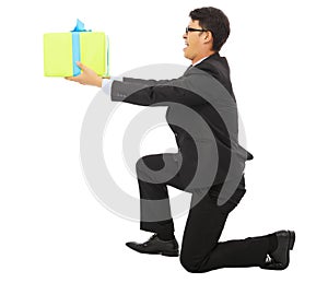 Young Business man holding a gift box and kneel.