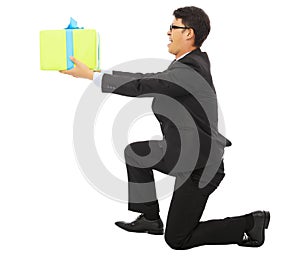 Young Business man holding a gift box and kneel. photo