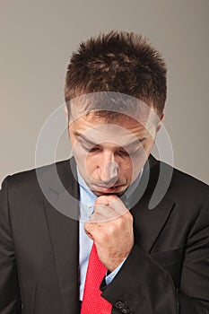 Young business man holding his hand to his chin