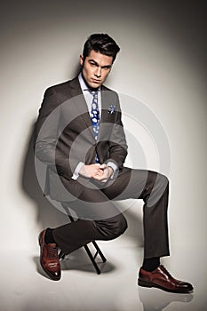 Young business man holding his hands together while sitting