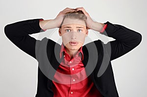 Young business man holding his head frowning with worry.
