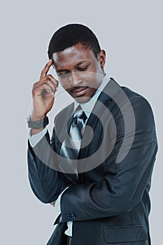 Young business man holding his head in pain against white background.