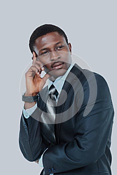 Young business man holding his head in pain against white background.