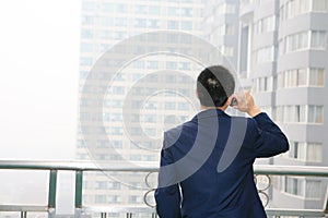 Young business man holding mobile phone