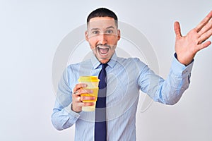 Young business man holding take away coffee over isolated background very happy and excited, winner expression celebrating victory