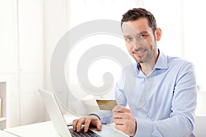 Young business man paying online with credit card