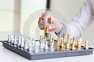 A young business man is playing chess, business strategy to be successful