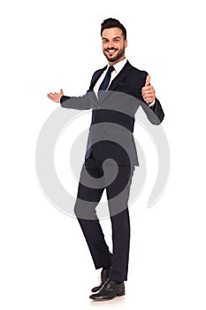 Young business man presenting and making the ok hand sign