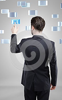 Young business man pressing a touchscreen button