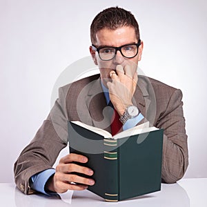 Young business man reads a scary book