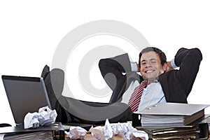 Young business man relaxes with feet at desk