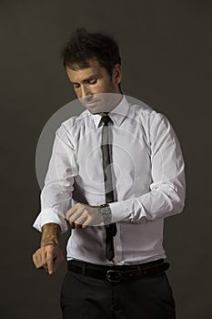 Young business man rolling up his sleeve and wearing a tie.