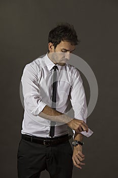 Young business man rolling up his sleeve and wearing a tie.
