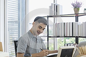 Young business man in shirt working using computer while sitting in work from home