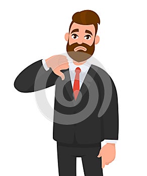 Young business man showing thumbs down sign, dislike, looks with negative expression and disapproval.