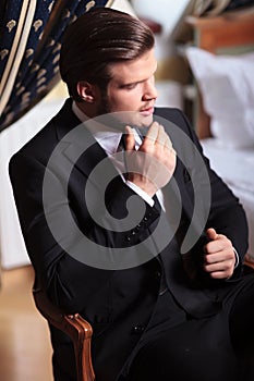 Young business man sits on vintage chair