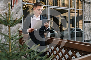 Young business man with a smartphone near of modern building