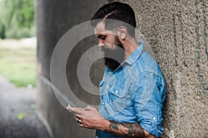 Young business man with smartphone on street. Talking on mobile phone. Smiling man with phone in the city. Businessman