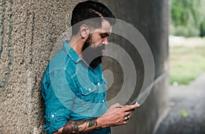 Young business man with smartphone on street. Talking on mobile phone. Smiling man with phone in the city. Businessman