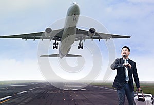 Young business man standing in airport runways with belonging lu