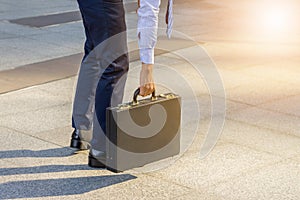 Young business man standing with his back carrying a briefcase c