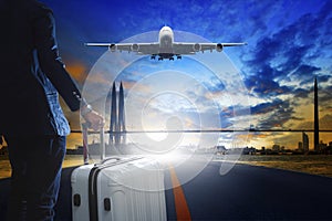 Young business man standing with luggage on urban airport runway